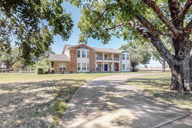 102 Cedar Dr, Oak Leaf, TX 75154 - view of front facade with a front lawn, a balcony, fence, and brick siding