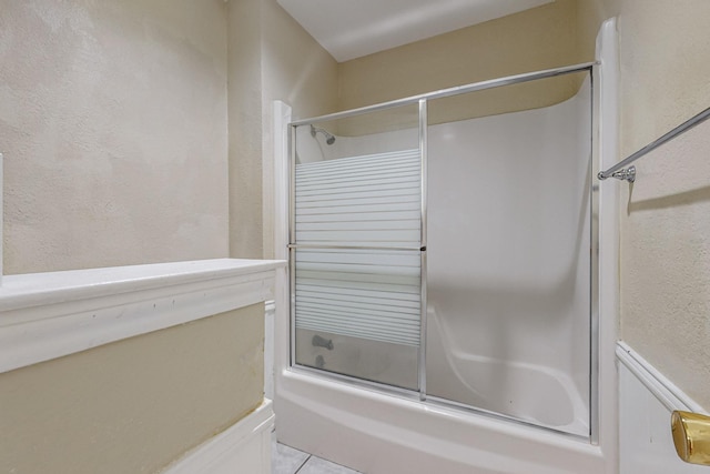 102 Cedar Dr, Oak Leaf, TX 75154 - full bathroom with a textured wall, tile patterned floors, and bath / shower combo with glass door