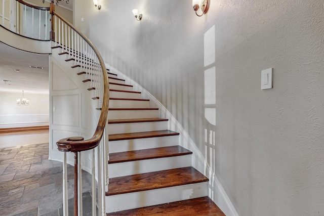 102 Cedar Dr, Oak Leaf, TX 75154 - stairway featuring a textured wall, a chandelier, and stone tile floors