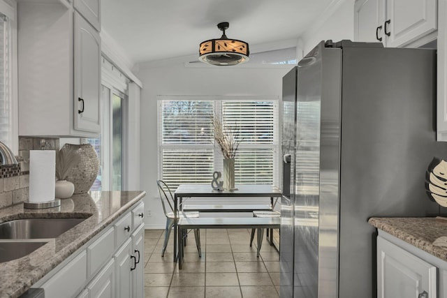 4901 Fairway Ct, De Cordova, TX 76049 - kitchen featuring white cabinetry, crown molding, light tile patterned floors, a sink, and freestanding refrigerator