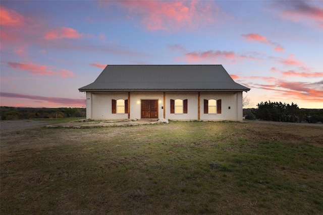 view of front of home with metal roof and a front yard