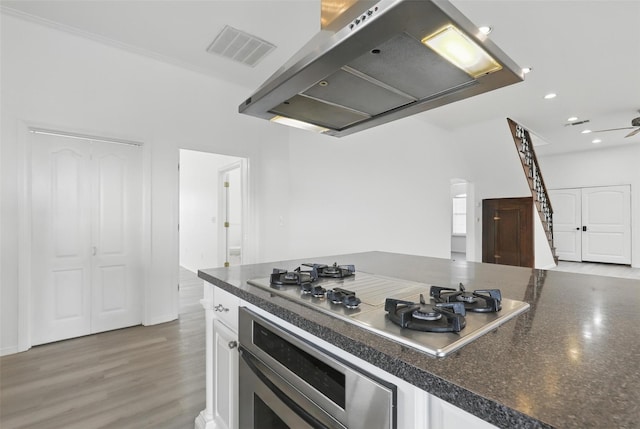 kitchen featuring visible vents, dark countertops, appliances with stainless steel finishes, under cabinet range hood, and white cabinetry