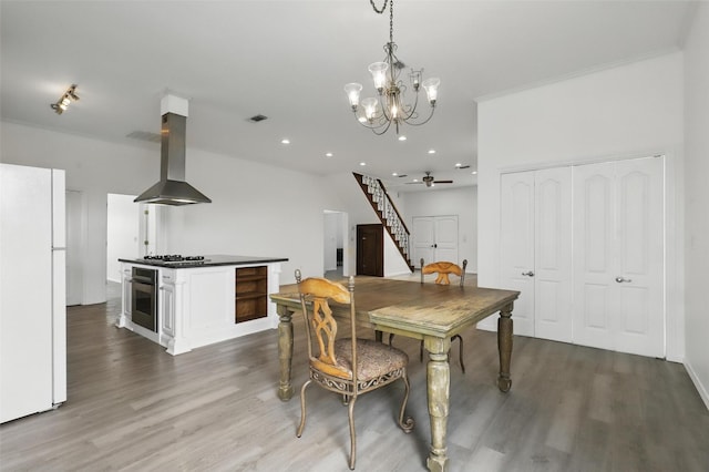 dining room with visible vents, a notable chandelier, stairs, and wood finished floors