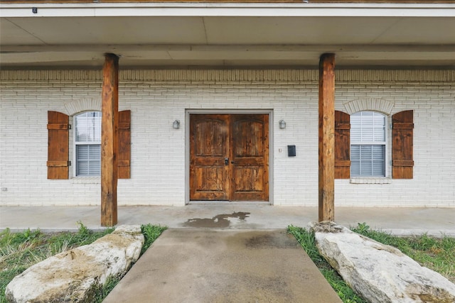 doorway to property with brick siding