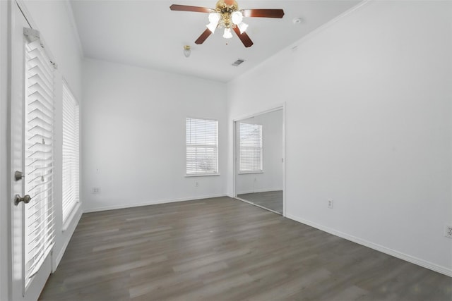 unfurnished room with baseboards, visible vents, wood finished floors, and a ceiling fan