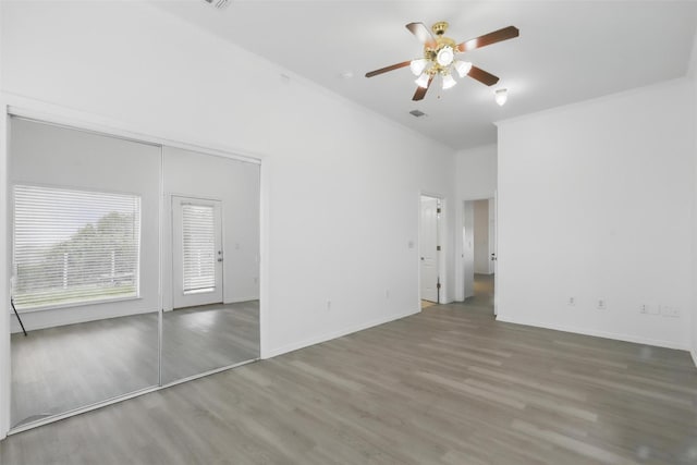 unfurnished bedroom featuring baseboards, crown molding, and wood finished floors