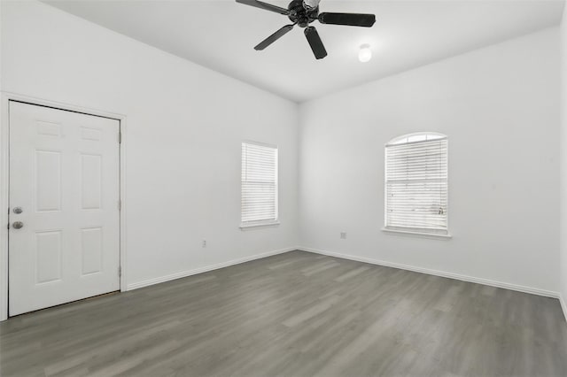 unfurnished room featuring baseboards, ceiling fan, wood finished floors, and a healthy amount of sunlight