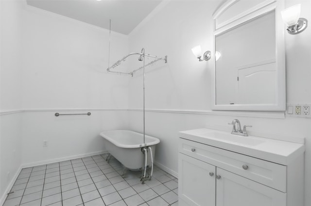 bathroom featuring tile patterned floors, vanity, a freestanding tub, and baseboards