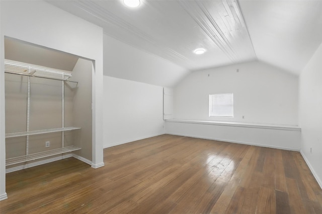 additional living space featuring hardwood / wood-style flooring, lofted ceiling, and baseboards