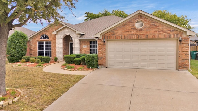view of front facade with a front yard, concrete driveway, brick siding, a shingled roof, and a garage
