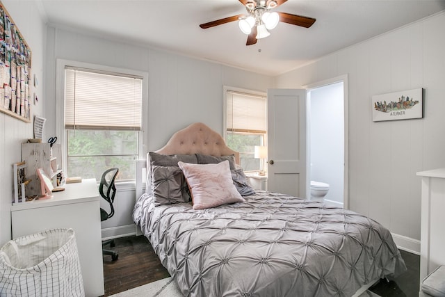 bedroom with baseboards, wood finished floors, ceiling fan, and ensuite bath