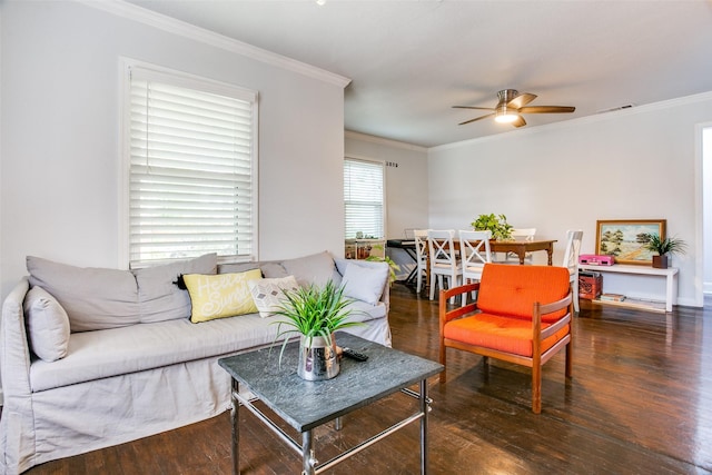 living room with a ceiling fan, visible vents, ornamental molding, and wood finished floors