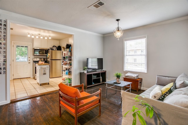living area featuring light wood-style floors, ornamental molding, a healthy amount of sunlight, and visible vents
