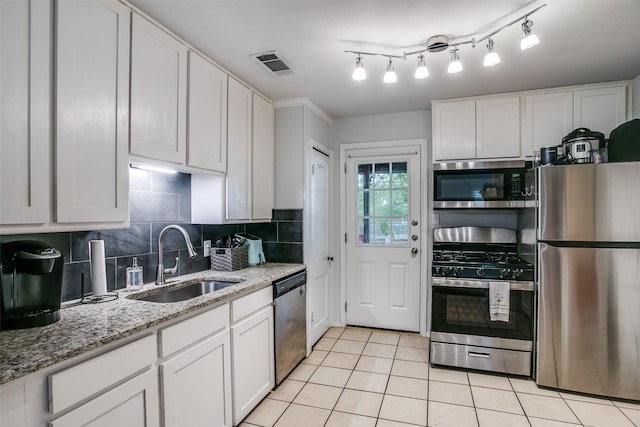 kitchen featuring tasteful backsplash, light tile patterned floors, stainless steel appliances, a sink, and visible vents