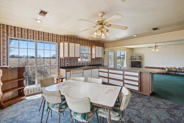 dining room featuring carpet floors, visible vents, and a ceiling fan