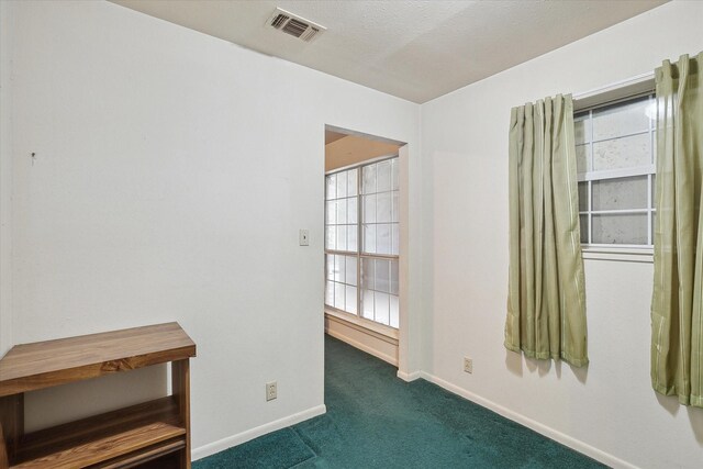 carpeted spare room with baseboards and visible vents