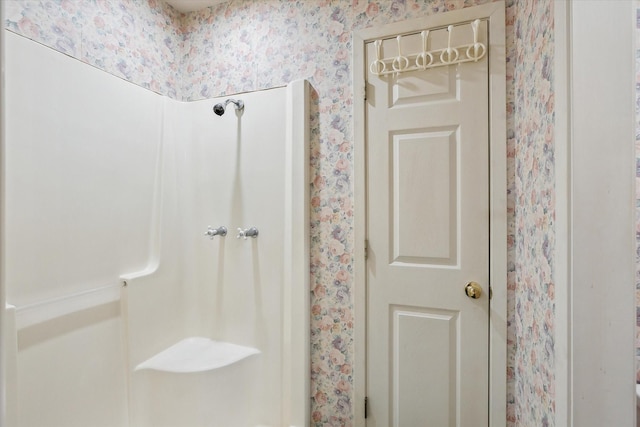 bathroom featuring wallpapered walls and walk in shower