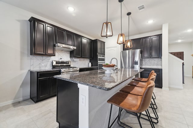 342 Meredith Dr, Fate, TX 75087 - kitchen with appliances with stainless steel finishes, under cabinet range hood, dark stone counters, baseboards, and recessed lighting