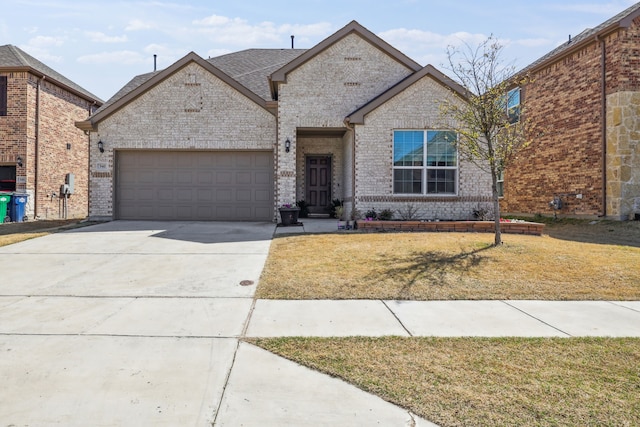 342 Meredith Dr, Fate, TX 75087 - view of front of home with an attached garage, concrete driveway, brick siding, and a front yard
