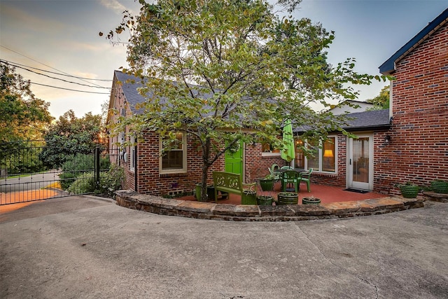 3241 Westcliff Rd W, Fort Worth, TX 76109 - view of front of house featuring brick siding, a gate, a patio area, and roof with shingles