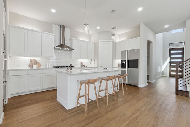 4516 Rustic Ridge Dr, Mckinney, TX 75071 - kitchen featuring wall chimney exhaust hood, refrigerator with ice dispenser, white cabinets, decorative backsplash, and recessed lighting