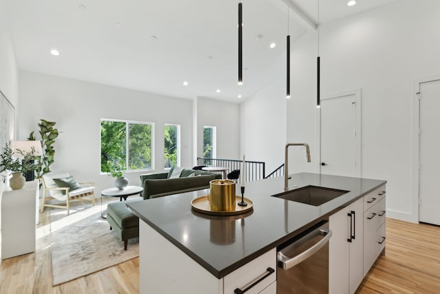 2142 Lovedale Ave Unit 101, Dallas, TX 75235 - kitchen with light wood finished floors, dark countertops, dishwasher, and a sink
