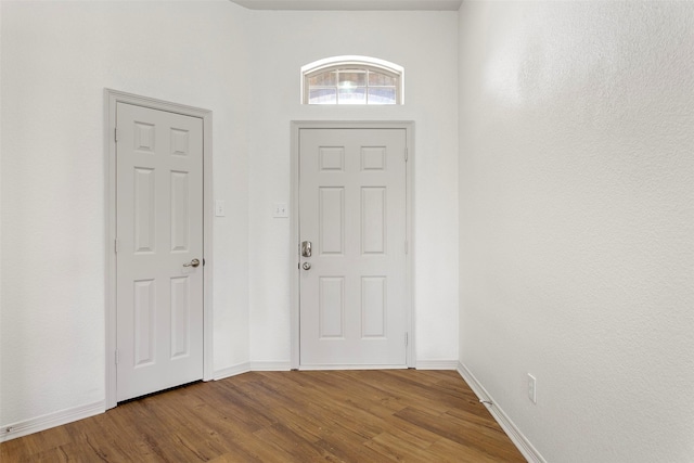 foyer featuring baseboards and wood finished floors