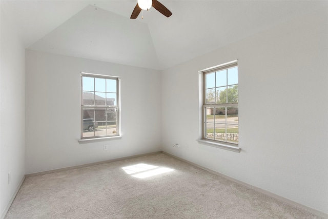 spare room featuring carpet flooring, lofted ceiling, a ceiling fan, and a healthy amount of sunlight
