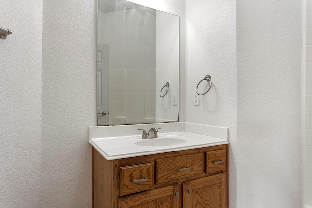 bathroom featuring vanity and a textured wall