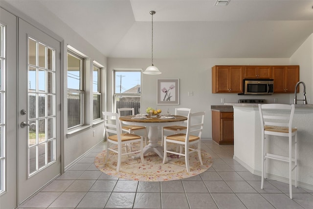 dining room featuring light tile patterned flooring, baseboards, and lofted ceiling