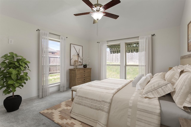 bedroom with light colored carpet, ceiling fan, multiple windows, and lofted ceiling