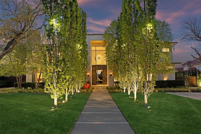 view of front of property featuring stucco siding and a lawn
