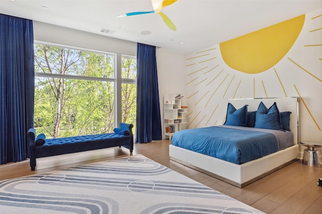 bedroom with visible vents, ceiling fan, and wood finished floors