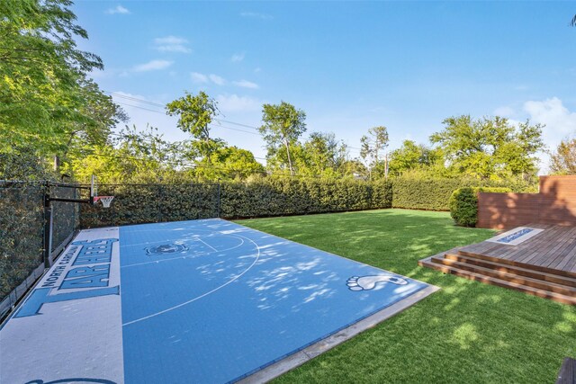 view of basketball court featuring a yard, fence private yard, and basketball court