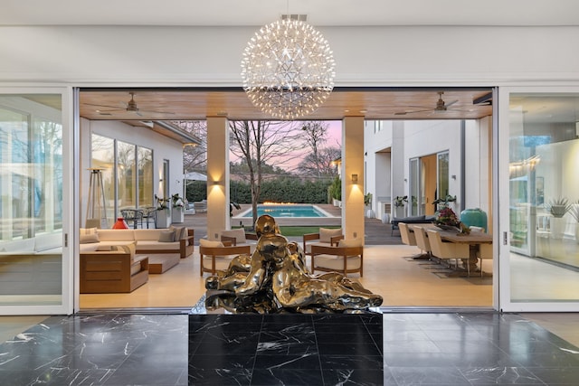 interior space with ceiling fan with notable chandelier, marble finish floor, visible vents, and a healthy amount of sunlight