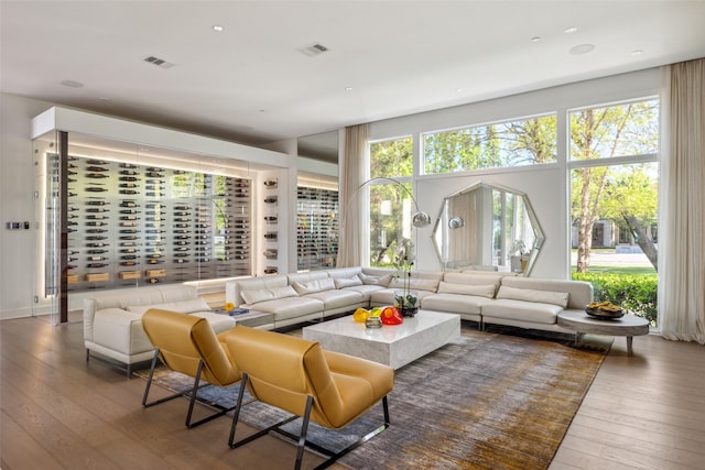 living area with visible vents, a wealth of natural light, and hardwood / wood-style floors