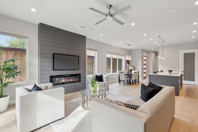 2228 Wycliff Ave, Dallas, TX 75219 - living room featuring a fireplace, recessed lighting, ceiling fan, and light wood finished floors