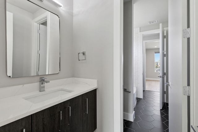 2228 Wycliff Ave, Dallas, TX 75219 - bathroom with tile patterned floors, visible vents, baseboards, and vanity