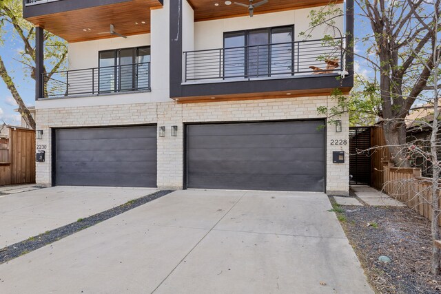 2228 Wycliff Ave, Dallas, TX 75219 - view of front of house with a balcony, fence, a garage, brick siding, and driveway