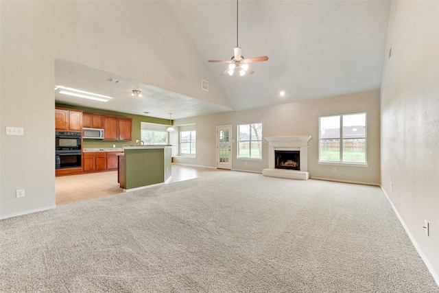 119 Valen Dr, Fate, TX 75189 - unfurnished living room featuring light colored carpet, a fireplace with raised hearth, high vaulted ceiling, baseboards, and ceiling fan