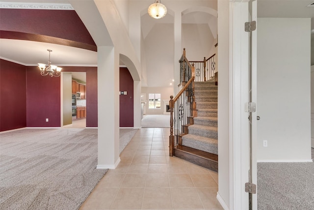 119 Valen Dr, Fate, TX 75189 - foyer entrance with light tile patterned flooring, stairs, a notable chandelier, light colored carpet, and arched walkways