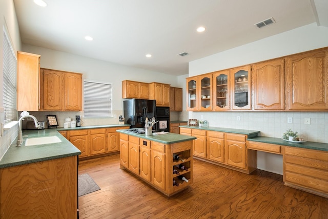 104 Cambridge Ct, Heath, TX 75032 - kitchen featuring a sink, black appliances, wood finished floors, a center island with sink, and recessed lighting