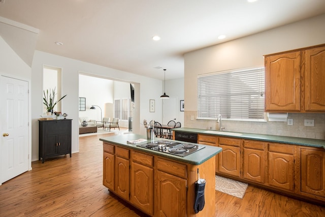 104 Cambridge Ct, Heath, TX 75032 - kitchen with a sink, light wood finished floors, a center island, decorative backsplash, and black appliances