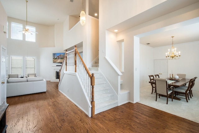 104 Cambridge Ct, Heath, TX 75032 - stairs with a towering ceiling, wood finished floors, a ceiling fan, and a chandelier