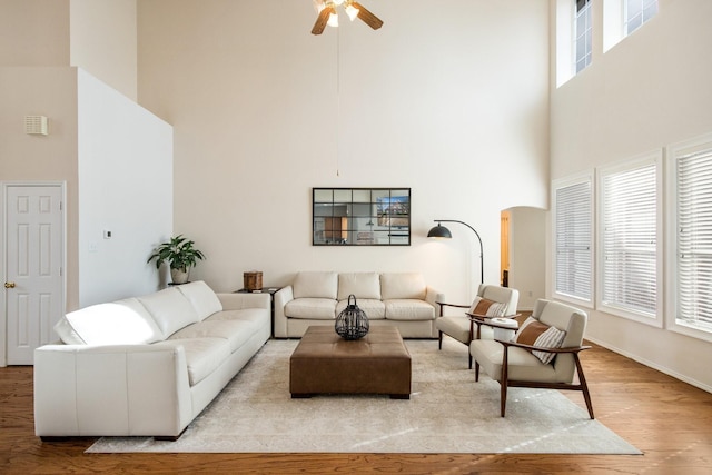 104 Cambridge Ct, Heath, TX 75032 - living area featuring a towering ceiling, wood finished floors, arched walkways, ceiling fan, and baseboards