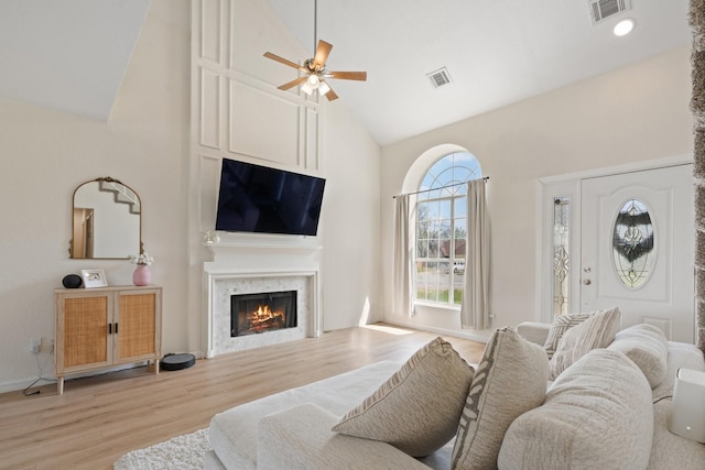 1029 Danforth Ct, Arlington, TX 76017 - living room with a warm lit fireplace, high vaulted ceiling, visible vents, and wood finished floors