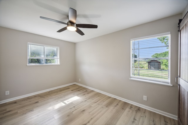 spare room with baseboards, ceiling fan, and light wood-style flooring