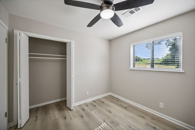 unfurnished bedroom with light wood-style flooring, baseboards, visible vents, a ceiling fan, and a closet