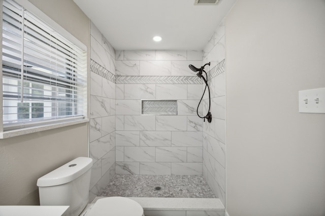 bathroom featuring toilet, recessed lighting, a tile shower, and visible vents