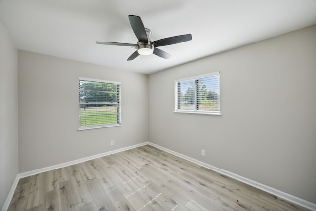 empty room with baseboards, a wealth of natural light, and light wood-style floors